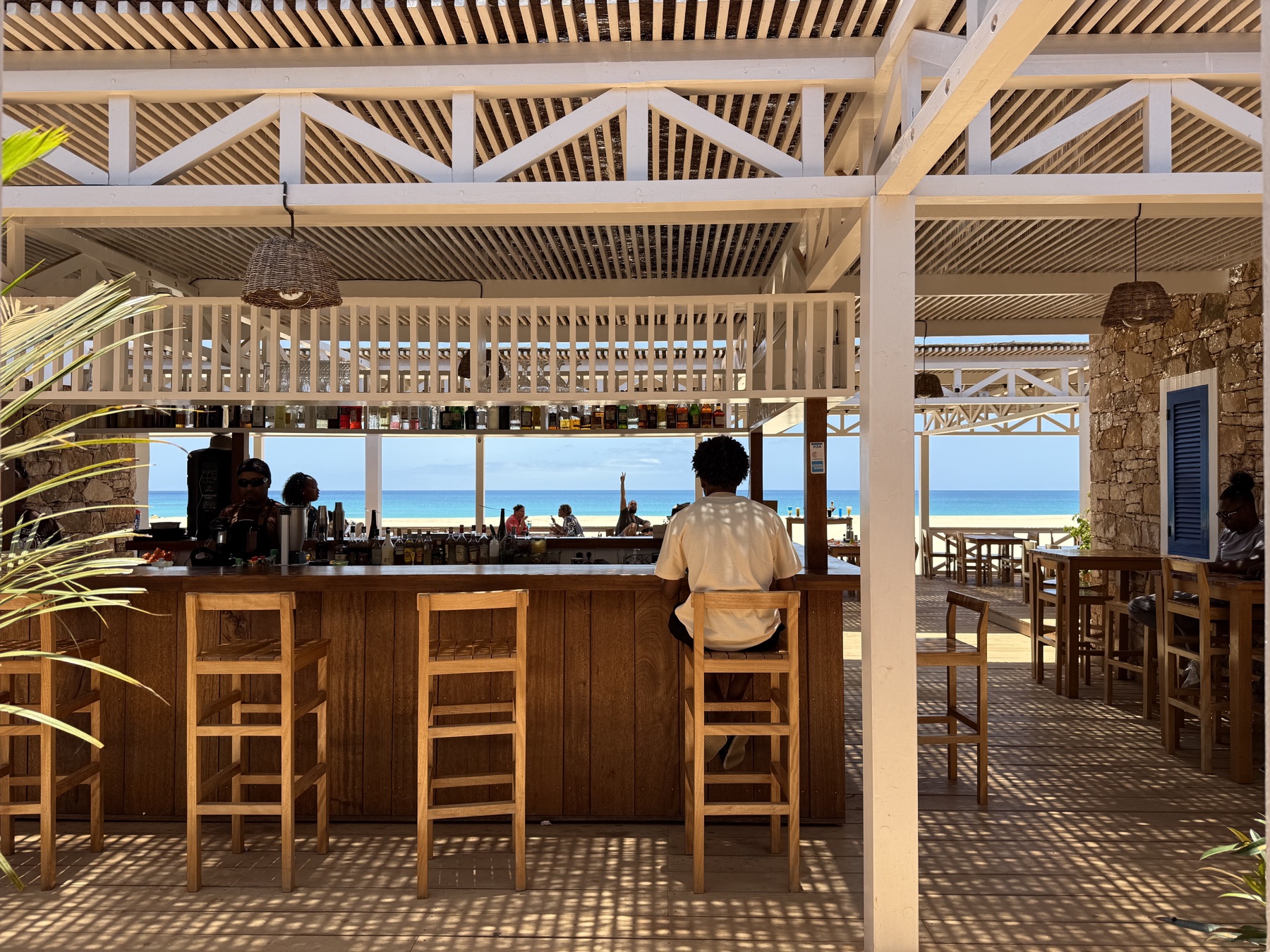 Le bar en bois, tabourets, ouvert sur la mer